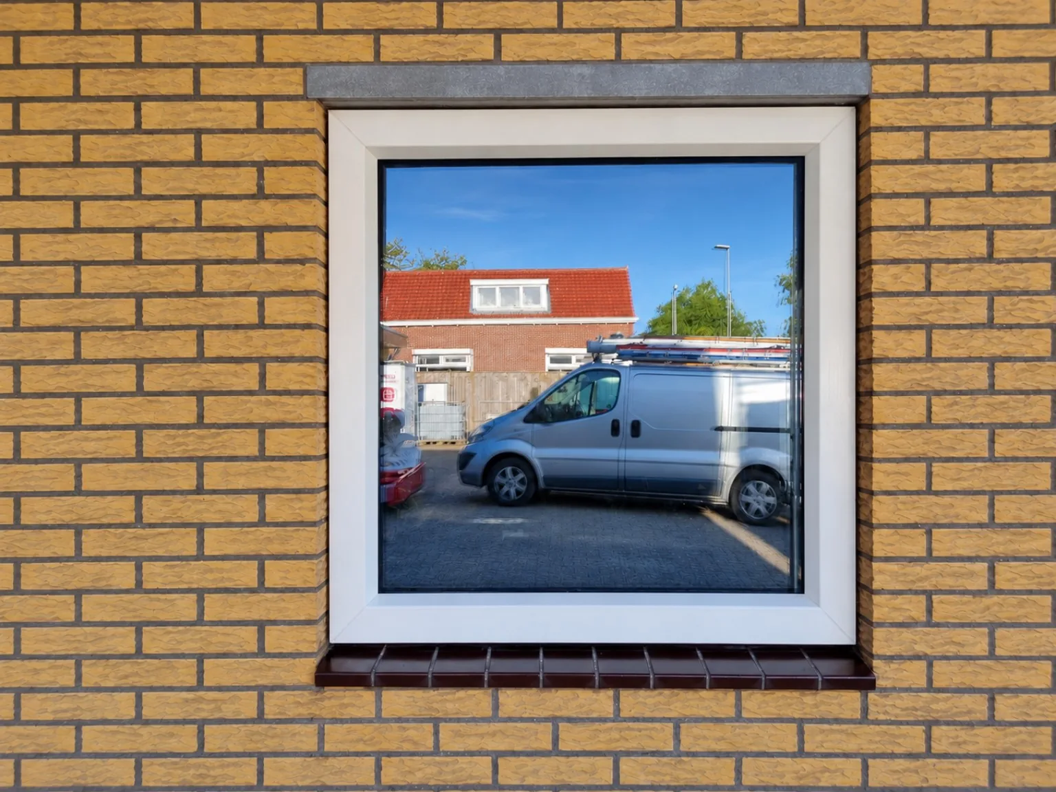 Wit kunststof kozijn in een gemetselde gevel
